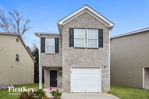 A house with a garage door is for sale by FirstKey Homes.