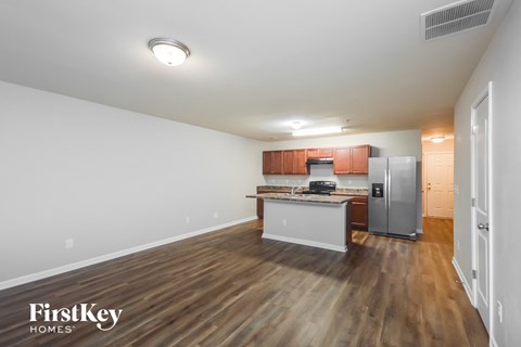 A kitchen with wooden floors and white walls.