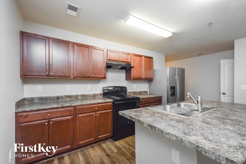 A kitchen with wooden cabinets and a granite countertop.