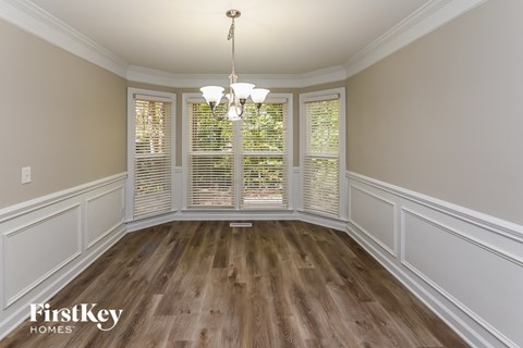 a dining room with wood flooring and a large window