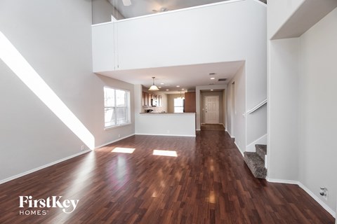 A spacious room with wooden floors and white walls.