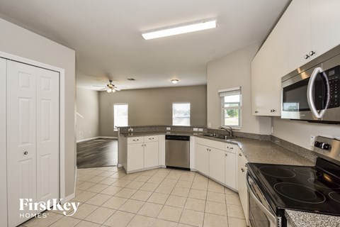 A kitchen with white cabinets and a black stove top oven.