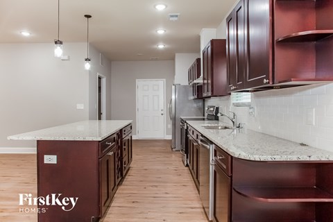 A kitchen with dark brown cabinets and a white countertop.