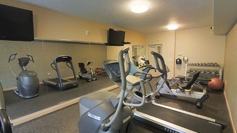 A gym with elliptical machines and weights.