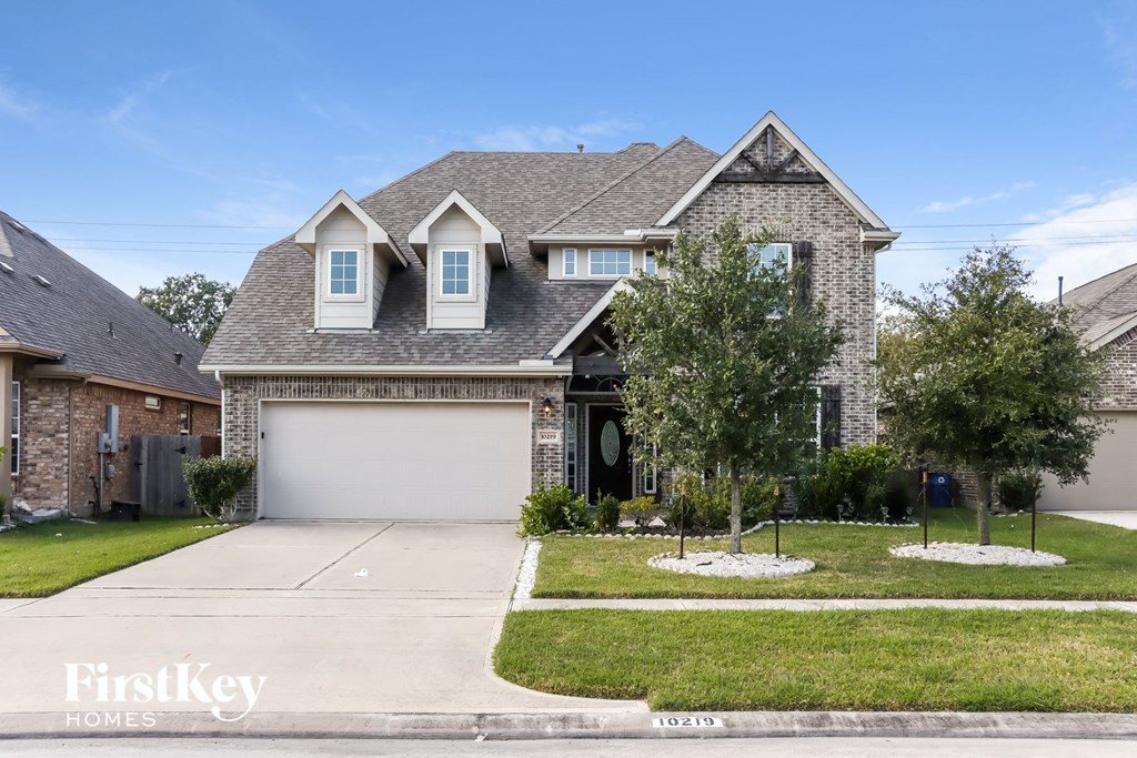 front view of a house with a large yard and a garage