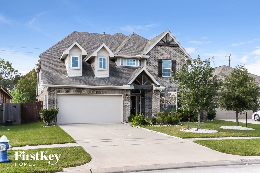 a brick house with a gray roof and a white garage door