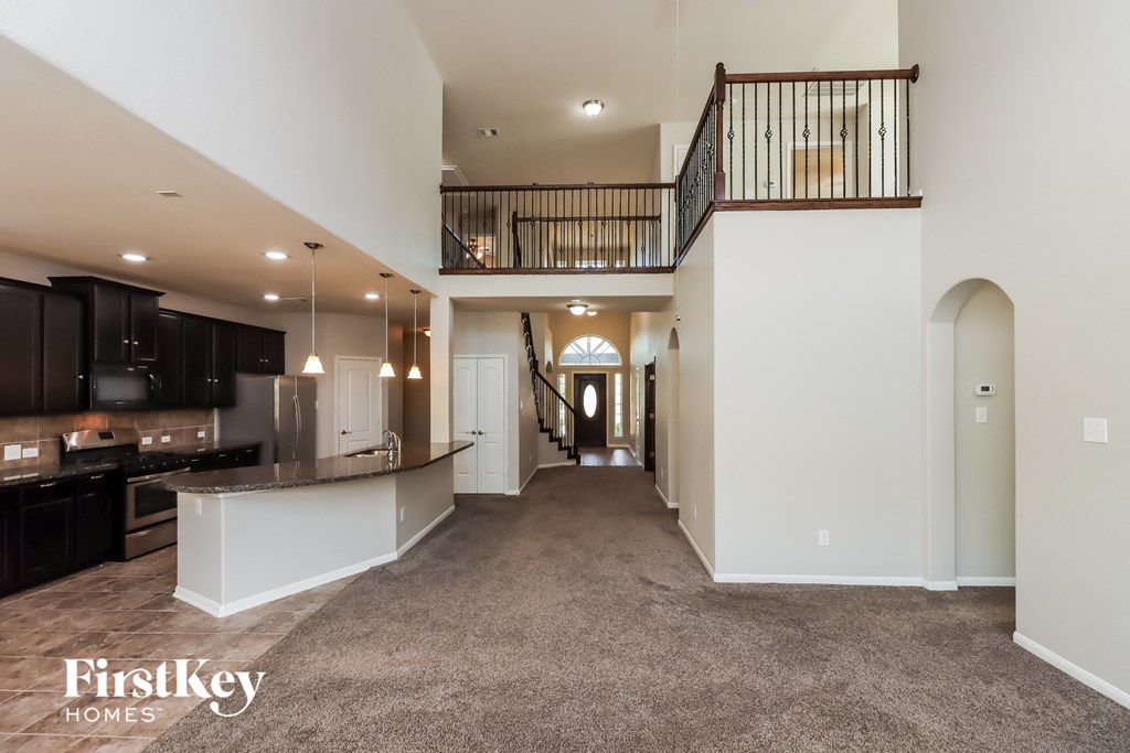 a large living room with a kitchen and a staircase