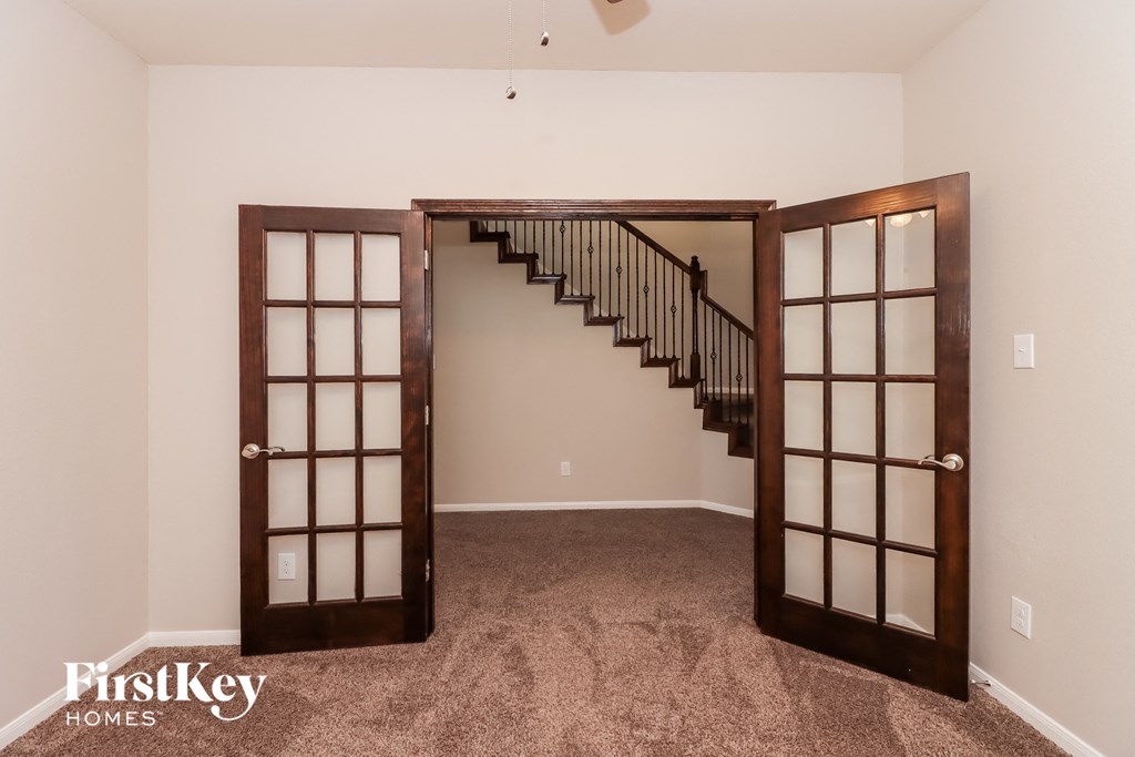 a basement with a staircase and two doors and carpeting