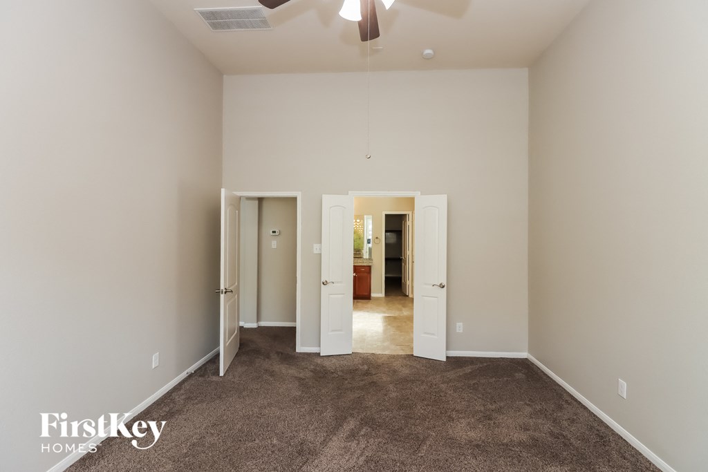 a living room with carpet and a ceiling fan