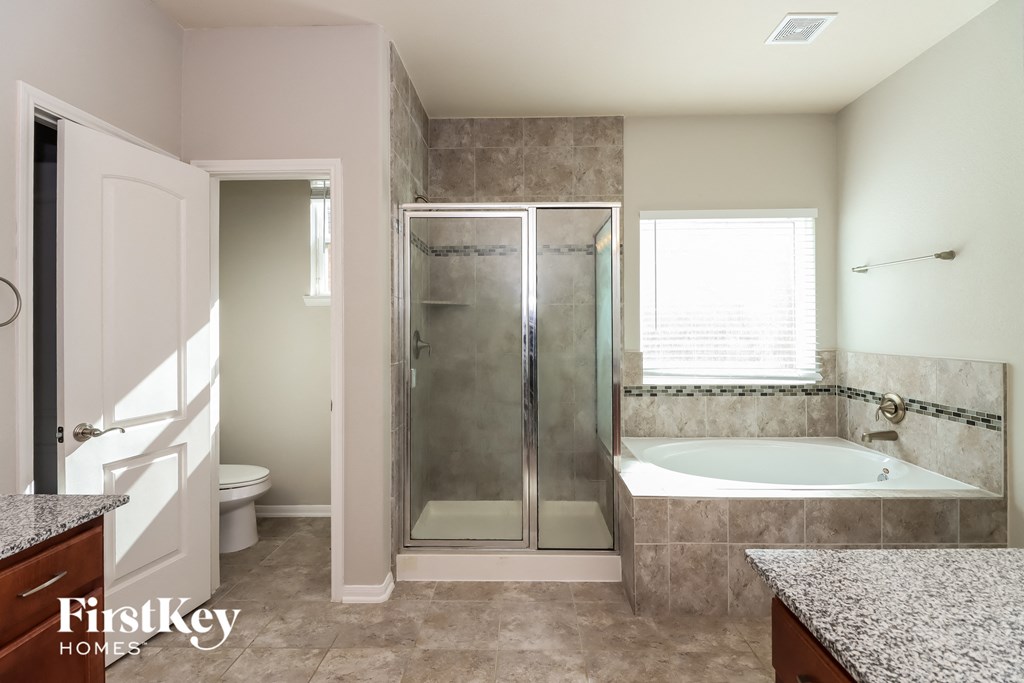 a bathroom with a tub and a shower and a sink