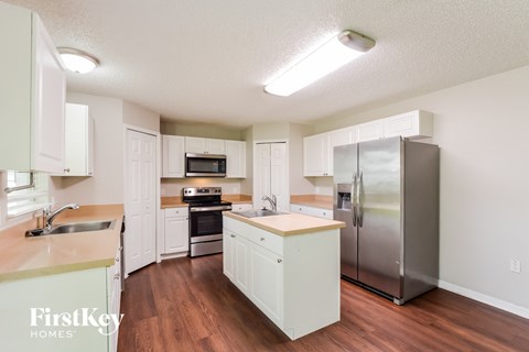 a kitchen with white cabinets and a stainless steel refrigerator