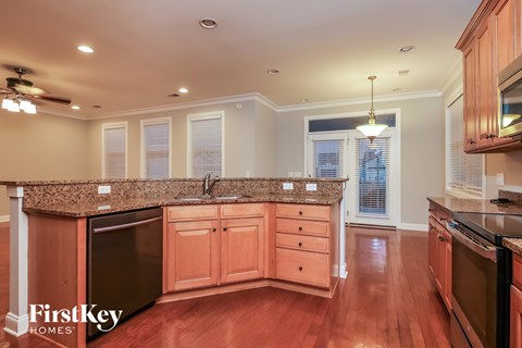 A kitchen with wooden cabinets and a granite countertop.