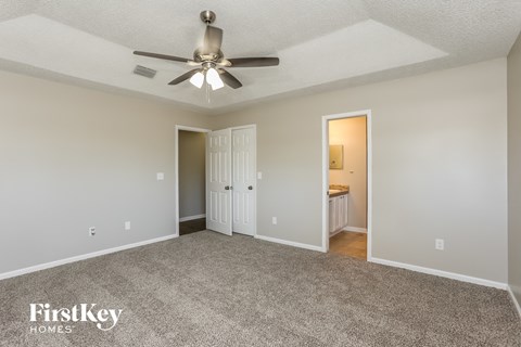 a living room with carpet and a ceiling fan