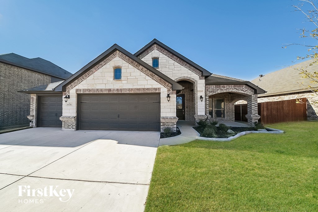 a house with a garage door and a driveway in front of it