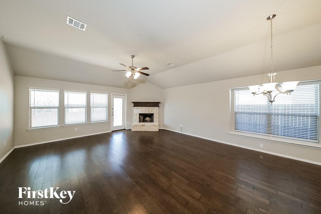 an empty living room with wood floors and a fireplace