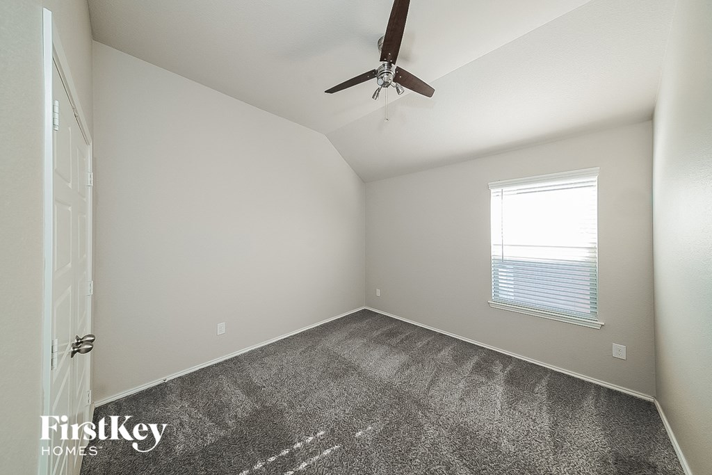 a bedroom with carpet and a ceiling fan