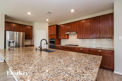 a kitchen with granite counter tops and wooden cabinets