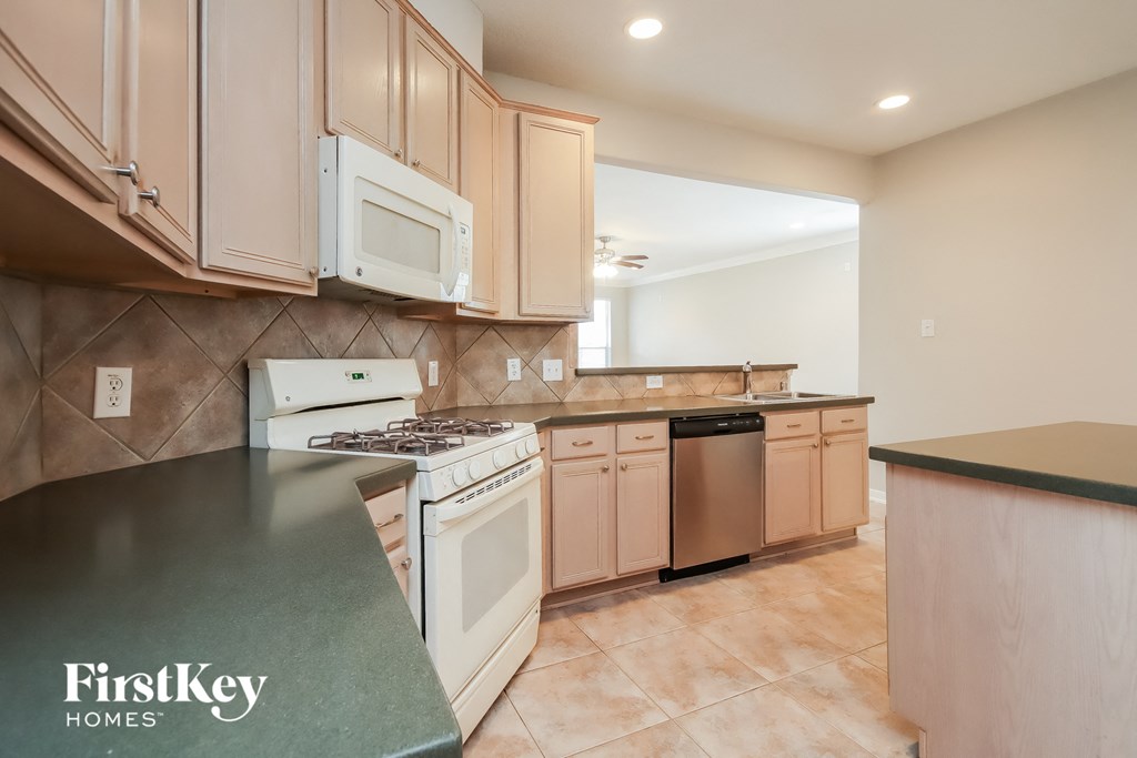 an updated kitchen with white appliances and white cabinets