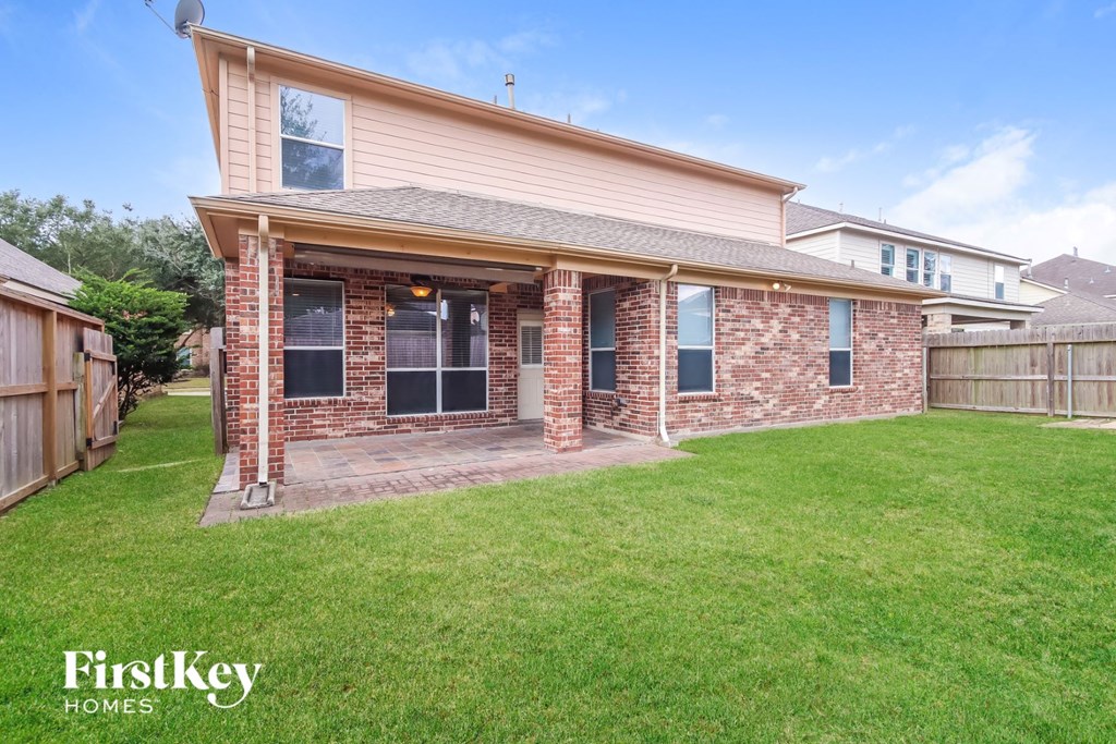 a brick house with a grass yard and a patio