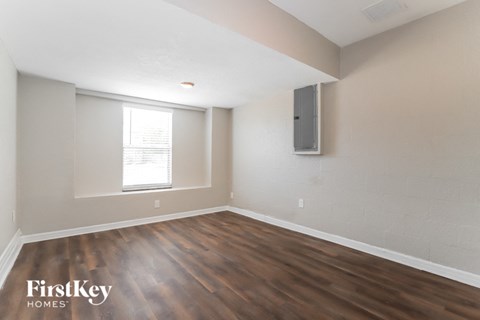 the living room of an apartment with wood flooring and a tv