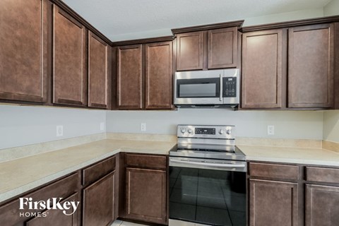 A kitchen with brown cabinets and a stove top oven.