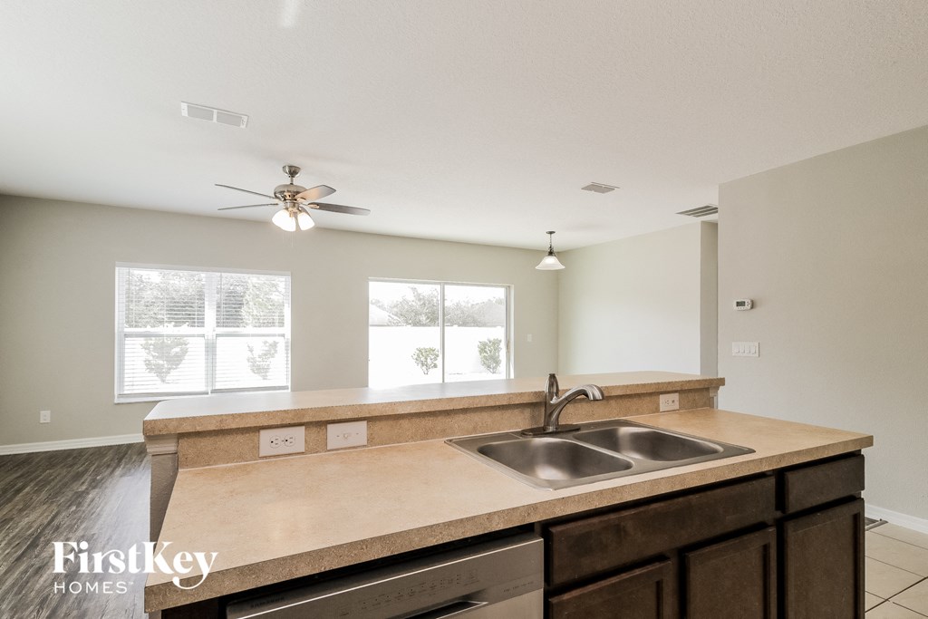 A kitchen with a sink and a fan on the ceiling.