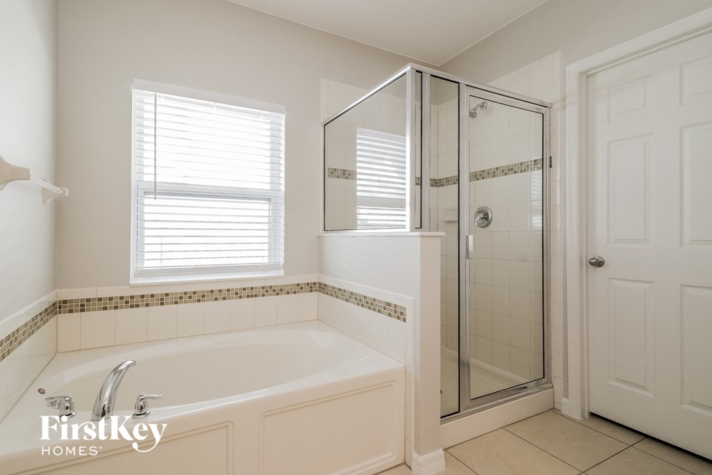 A white bathroom with a tub and a walk in shower.