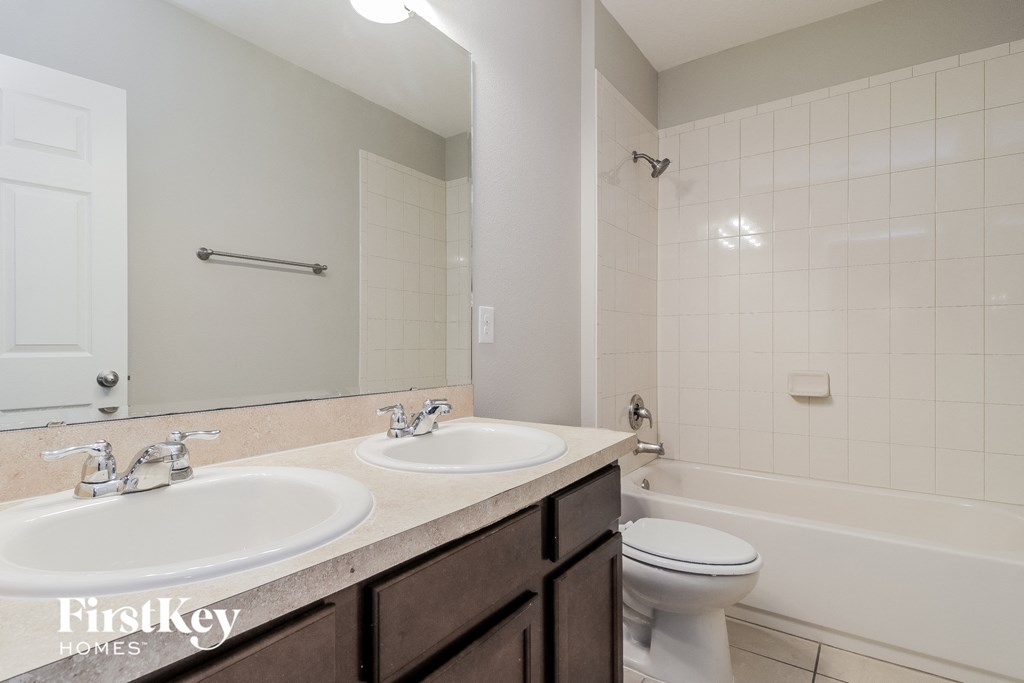 A white bathroom with a toilet, sink, and bathtub.