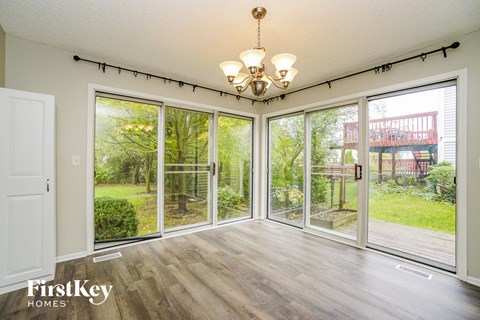 a living room with large windows and a chandelier