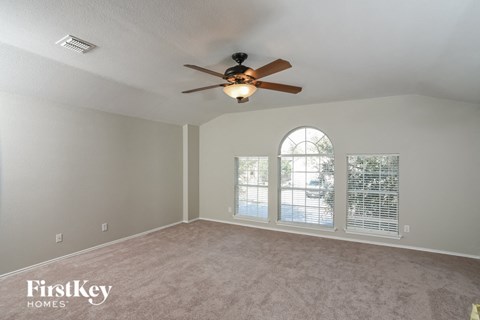 a living room with a ceiling fan and a window