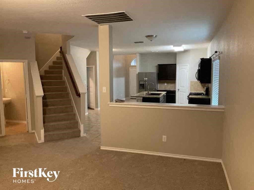 A spacious room with a staircase leading to the upper floor.