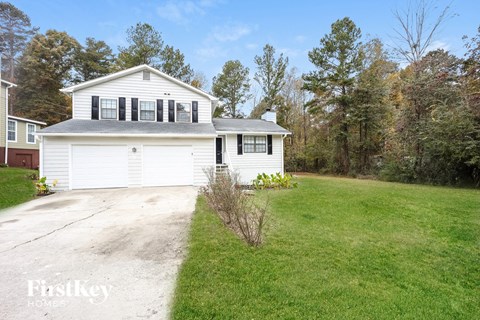 A two-story house with a garage and a driveway.