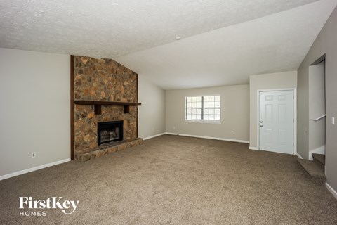 A living room with a fireplace and a door to the right.
