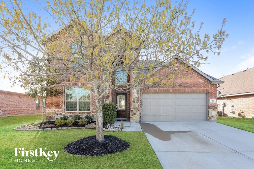 front view of a brick house with a tree in the front yard