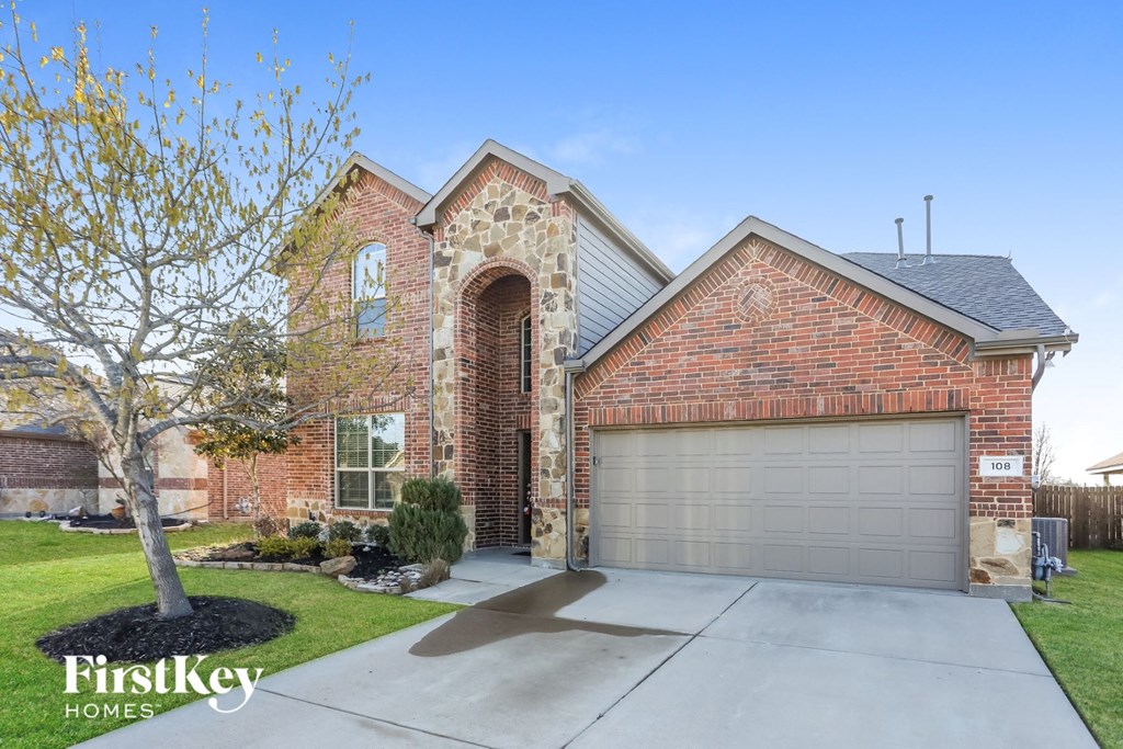 new home with brick and stone exterior and a garage