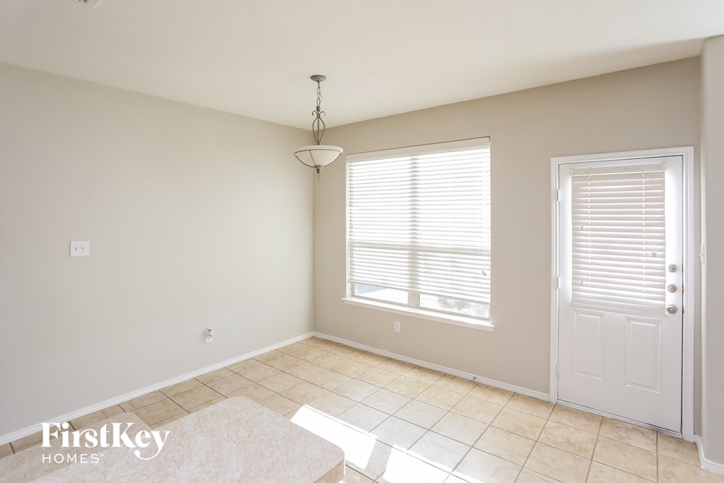 an empty dining room with a door and a window