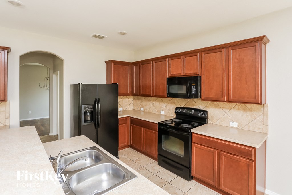 a kitchen with black appliances and wooden cabinets