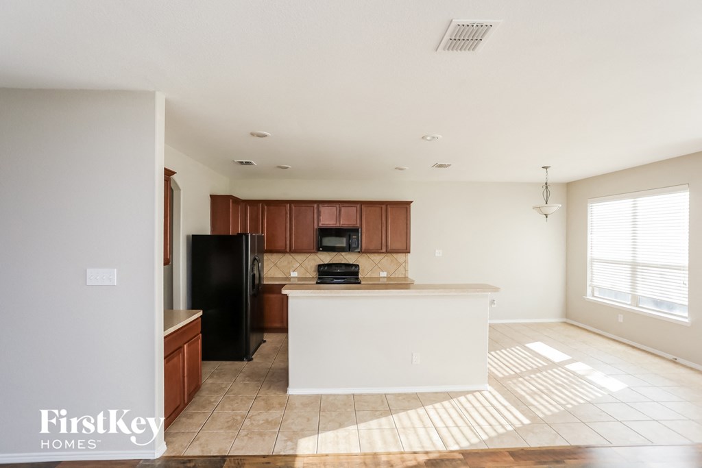 a kitchen with a large island and a black refrigerator