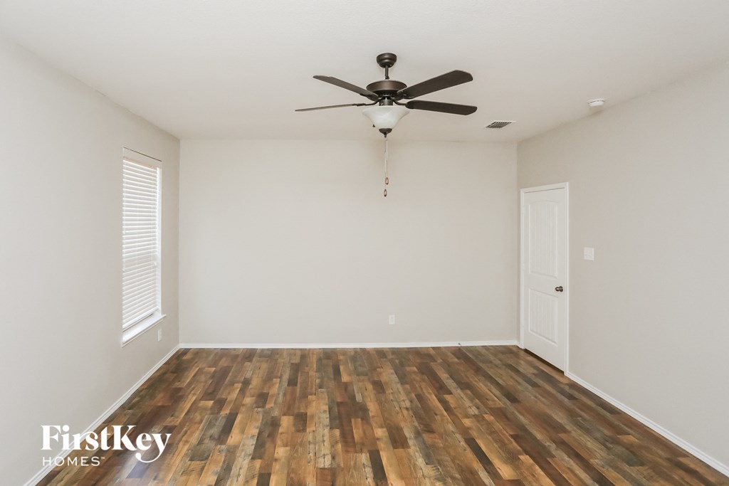 a living room with wood flooring and a ceiling fan