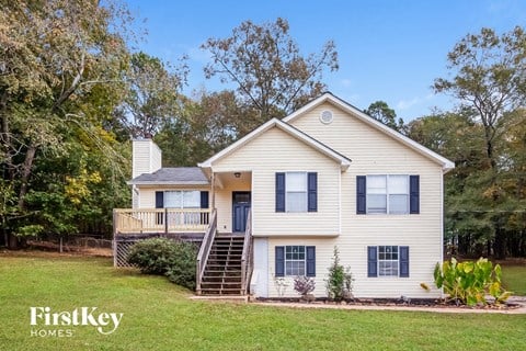 a white house with a deck and a yard