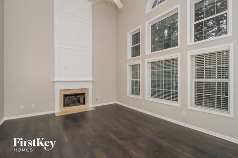 A room with a fireplace and a window with blinds.