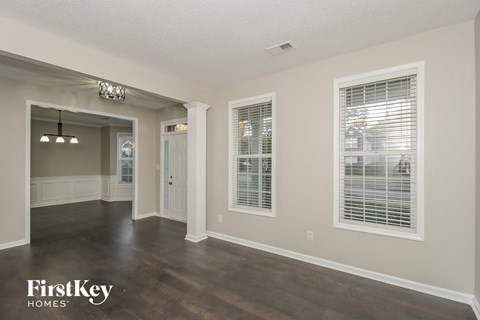 A spacious room with wooden floors and a chandelier.