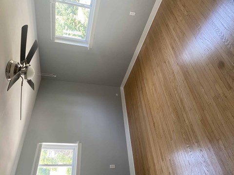 a room with a ceiling fan and a wooden floor
