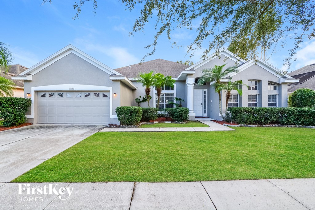 A house with a garage and a driveway in front of it.