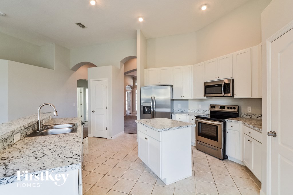 A kitchen with a granite countertop and stainless steel appliances.