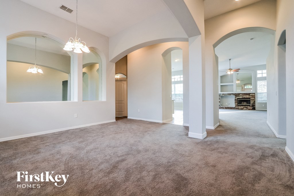 A spacious room with arched doorways and a carpeted floor.