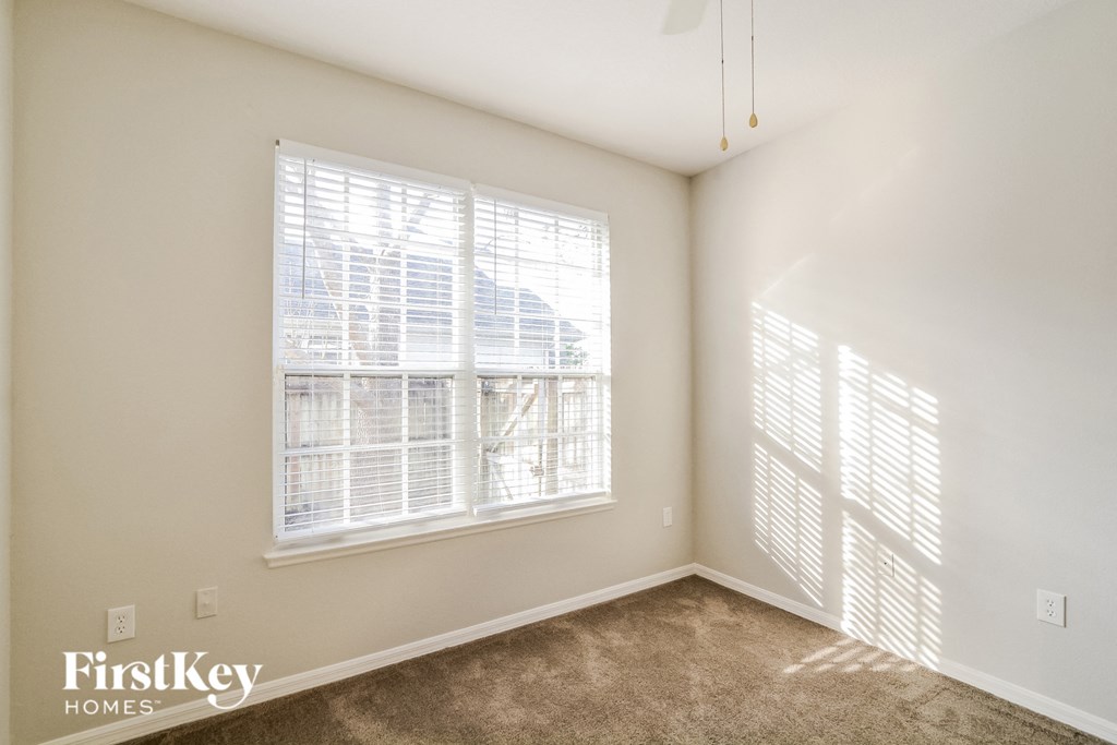 A room with a window and a carpet on the floor.