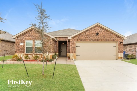 front view of a brick house with a driveway and a garage door