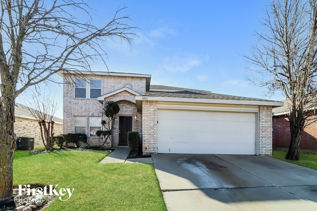 A house with a garage and a driveway in front of it.