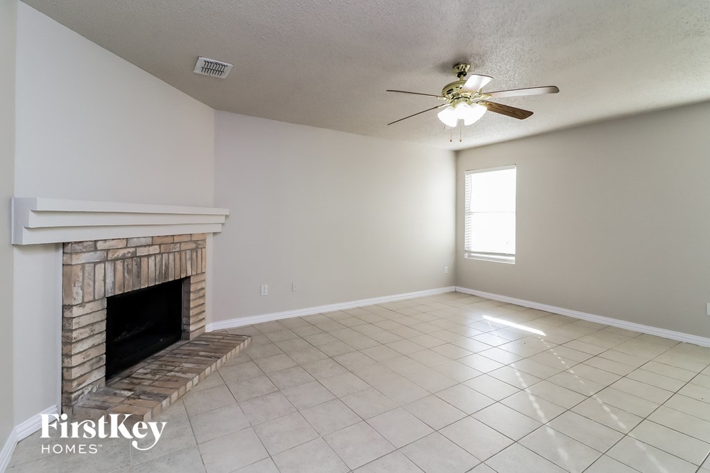 A room with a fireplace and a ceiling fan.